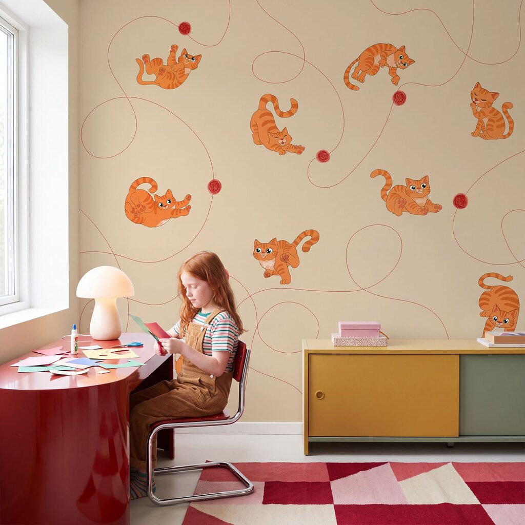 Gatitos con ovillos rojos en un interior
