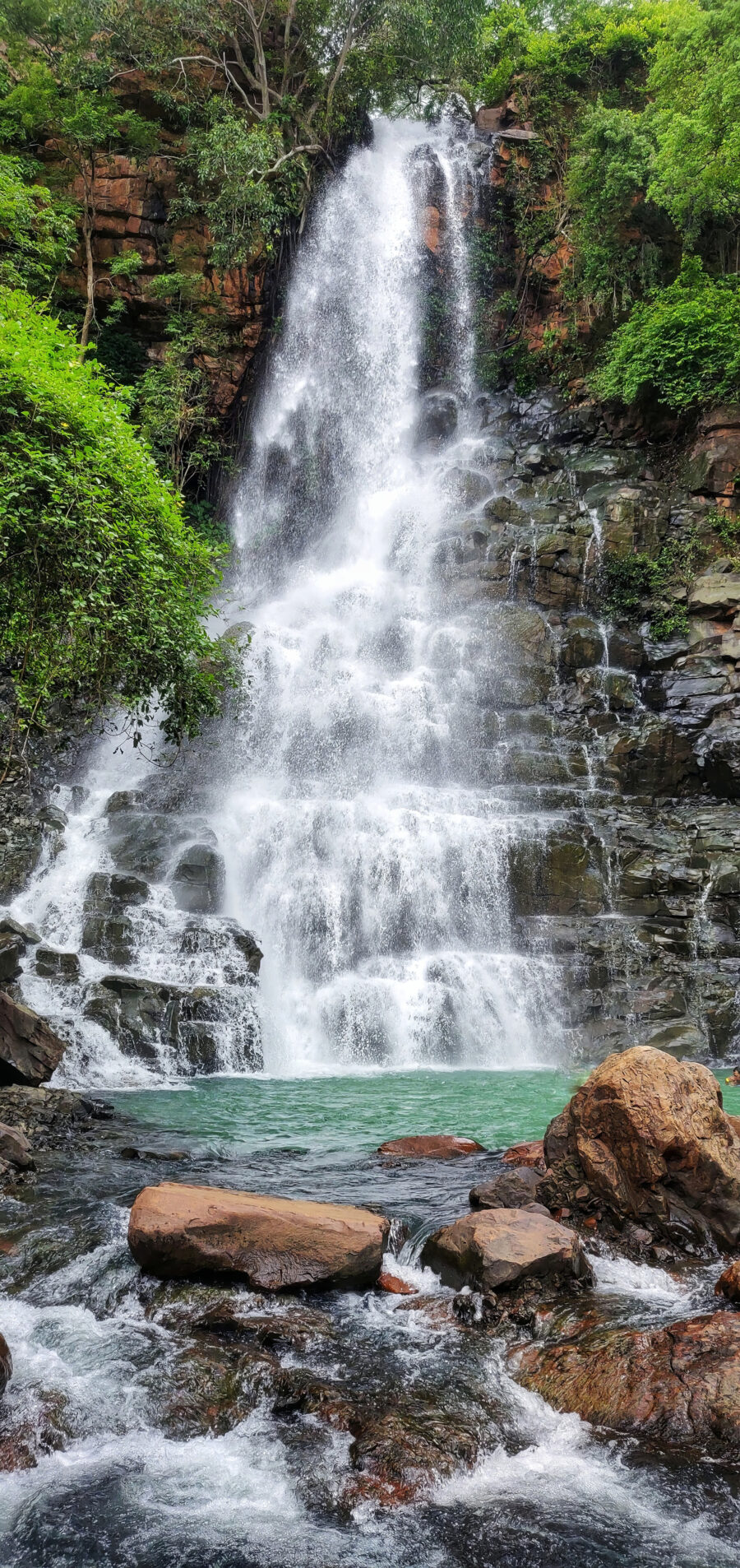Cascada entre rocas oscuras — diseño completo